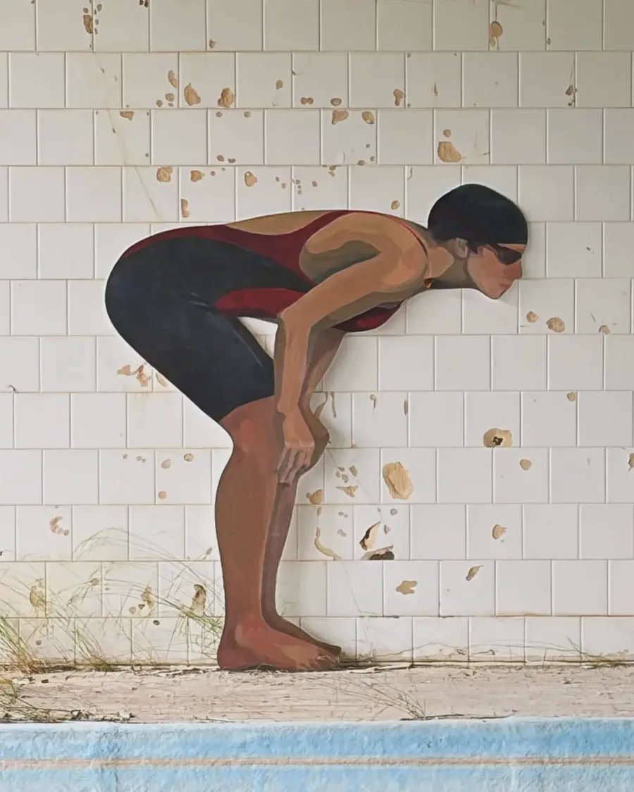 The painted swimmer in profile against the peeling white tiles of the abandoned pool.